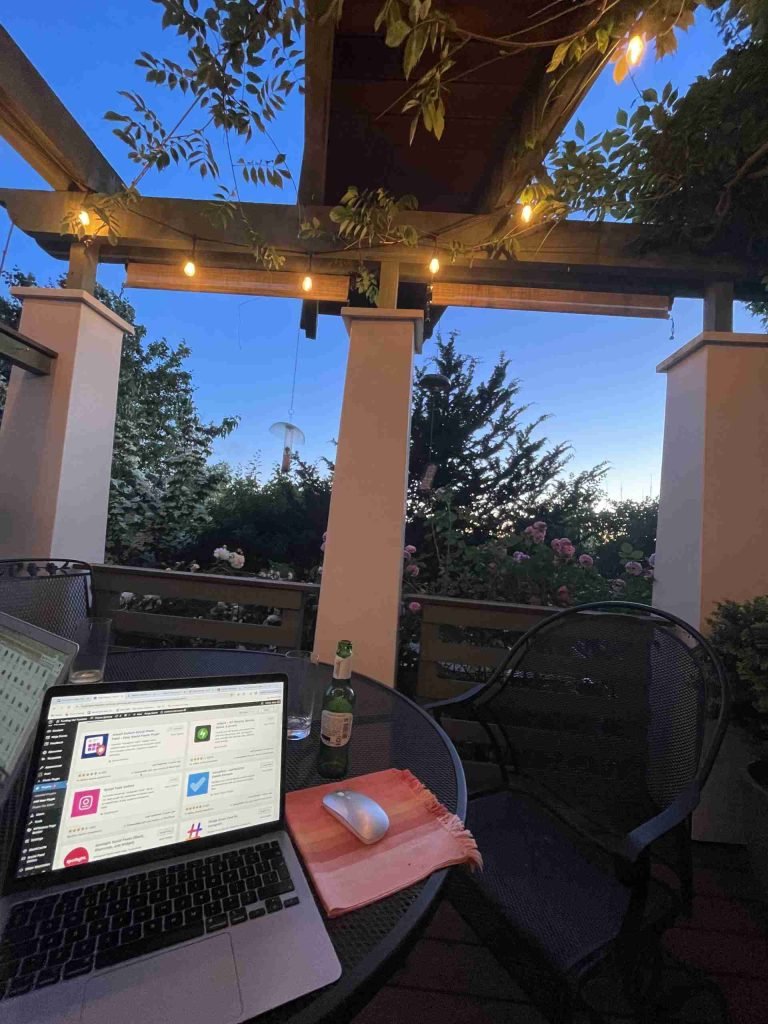 Laptop on a table in a garden in Seattle at dusk.
